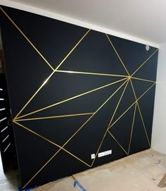 a black wall with gold lines painted on it