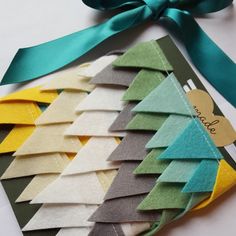 there are many pieces of paper that have been made into christmas tree decorations with ribbons