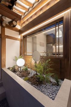 the interior of a japanese house with plants and rocks