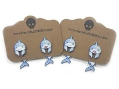 two blue and white shark earrings with skulls on the back are shown next to each other