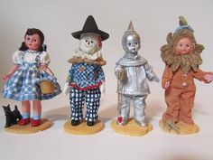 four dolls are standing next to each other