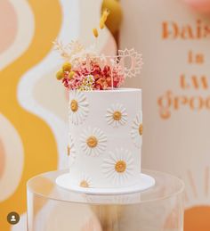 a white cake with daisies and flowers on top