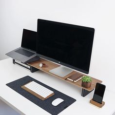 a computer desk with a laptop, monitor and phone on it