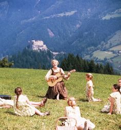 a group of people sitting on top of a lush green hillside