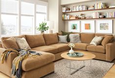 a living room filled with furniture and bookshelves next to a window covered in windows