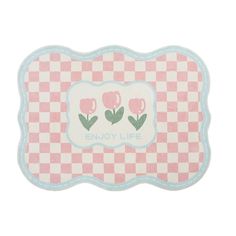 a pink and white checkered placemat with flowers on the border that says enjoy life