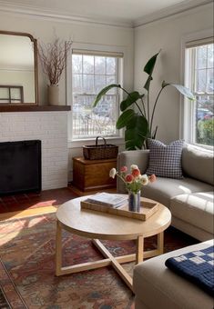 a living room filled with furniture and a fire place in front of a mirror on the wall