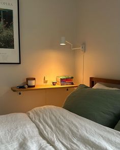 an unmade bed with white sheets and green pillows