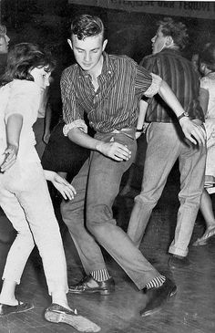 an old black and white photo of people dancing