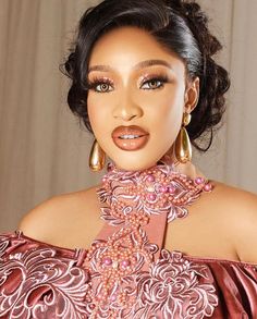 a woman in an off the shoulder dress with large hoop earrings