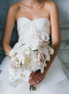 a bride holding a bouquet of white and pink flowers