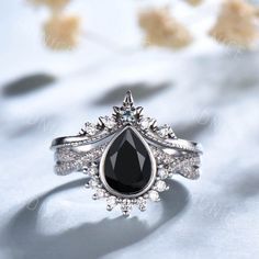 a black and white diamond ring sitting on top of a table