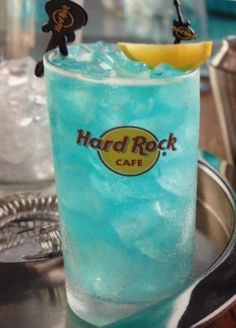 a blue drink with a lemon wedge on the rim and hard rock cafe's logo