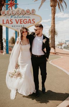 a bride and groom walking in front of the welcome to las vegas sign at their wedding