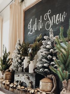 a mantel decorated with christmas trees and other holiday decorations, such as pine cones