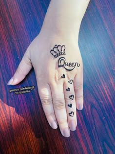 a woman's hand with the word queen written on it and hearts drawn in black ink