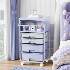 a blue and white cart with drawers in a bedroom