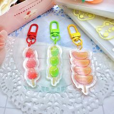 four plastic candy lollipops are on a doily next to a book