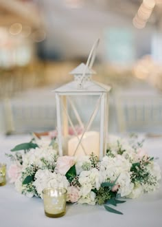 a white table topped with a candle and flowers