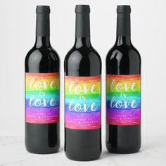 three bottles of wine with the words love is love painted on one bottle and the word love is love written on the other