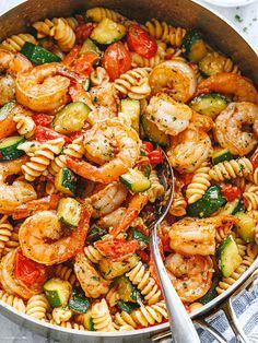 pasta with shrimp, zucchini and tomatoes in a skillet