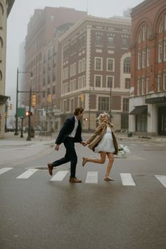 a man and woman crossing the street holding hands