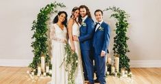 a group of people standing next to each other in front of candles and greenery