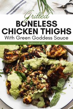 grilled boneless chicken thighs with green goddess sauce on a white plate, garnished with fresh herbs