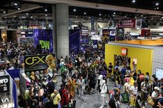 a crowd of people walking around a convention hall