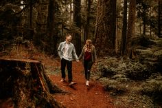 a man and woman are walking through the woods