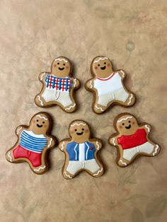 four decorated ginger cookies sitting on top of a table