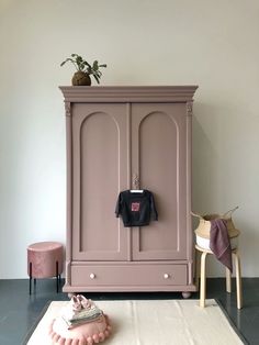 a pink armoire with a t - shirt hanging on it's hanger