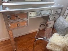 a silver desk with a mirror on it and a chair in front of the table