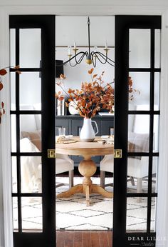 an open glass door leading into a dining room