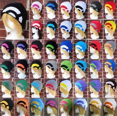 many different colored hats are on display in front of a brick wall with multiple heads