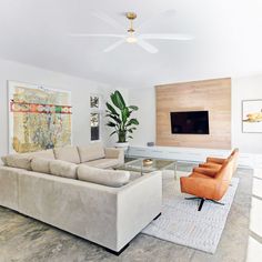 a living room with two couches and a flat screen tv mounted on the wall