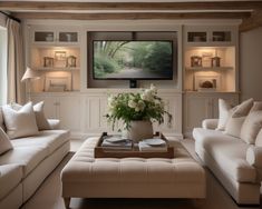 a living room filled with furniture and a flat screen tv mounted on the wall over a fireplace