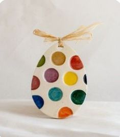 an egg shaped ornament decorated with multicolored dots