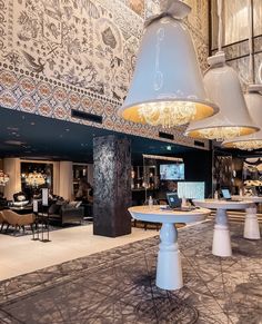 the interior of a restaurant with tables, chairs and chandeliers hanging from the ceiling