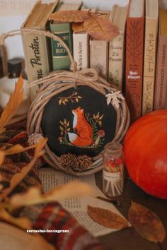 an image of some books and other items on a table with pumpkins in the background