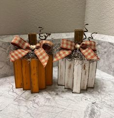 three wooden boxes with bows on them sitting on a marble counter top in front of a gray wall