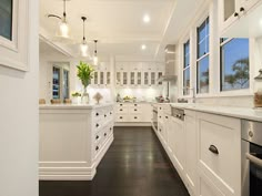 a large kitchen with white cabinets and black flooring is pictured in this image from the doorway