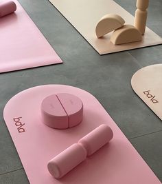 pink yoga mats and accessories on the floor in front of eachother's name