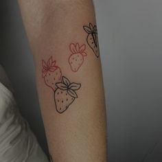 a woman's arm with three strawberries on the left side of her arm