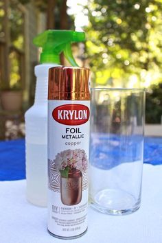 a bottle of krylon foil next to a glass with water and a green sprayer