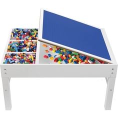 a white table with legos in it and a blue top on the bottom shelf