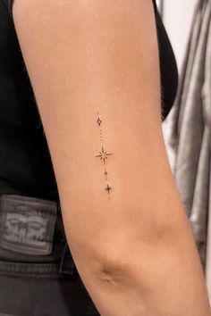 a woman's arm with a small star tattoo on the back of her left arm