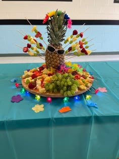 a pineapple is sitting on top of a platter of fruit