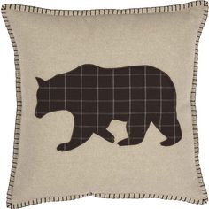 a black bear is shown on a beige pillow