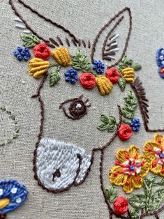 an embroidered horse with flowers on it's head